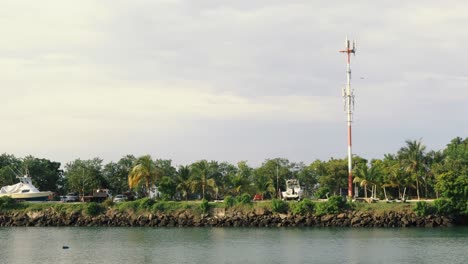 Pan-shot-of-the-commercial-docks-of-the-Panama-Canal,-heavy-machinery-used-to-lift-boats-out-of-the-water-for-repairs-and-maintenance-are-parked-on-the-bank,-Panama-City