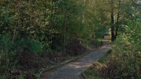 POV-Walking-On-Wooden-Path-at-Kypegården-and-Spotting-a-Yellow-Gazebo---Wide-Shot-Tracking-Forward-and-Turning