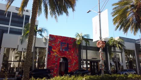 High-end-store-fronts-on-Rodeo-Drive,-palm-trees,-Dior-store-on-clear-sunny-afternoon