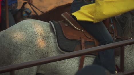 Cowboy-getting-down-with-pride-from-a-race-horse-at-Montana-Rodeo-USA