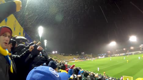 Enthusiastic-soccer-fans-of-football-team-Union-Saint-Gilles,-jumping-with-hands-raised-in-the-stadium