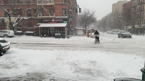 Conductor-De-Reparto-Monta-En-Bicicleta-En-La-Acera-A-Través-De-La-Nieve-Profunda-En-La-Ciudad-De-Nueva-York