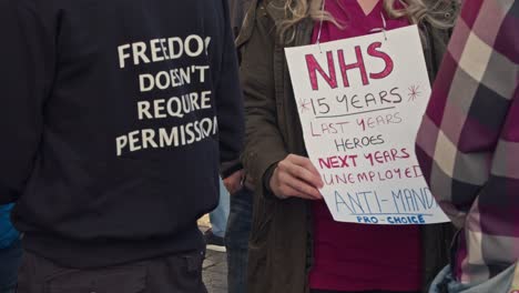 Close-up-of-placard-NHS-'15-years-last-years-heroes-next-years-unemployment'-nurse-demonstrating-during-extinction-rebellion-protest