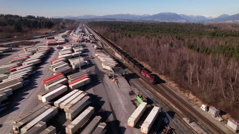 Luftaufnahme-Eines-Güterzuges,-Der-Auf-Der-Eisenbahn-Entlang-Des-Vancouver-Shipping-Terminals-In-Kanada-Fährt