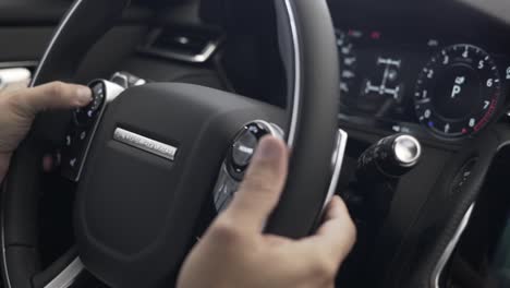 man-using-steering-wheel-of-new-range-rover-velar-,-modern-automobile,-land-rover-automobile