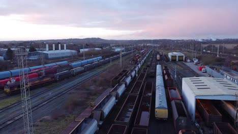 Aerial-view-over-long-train-yard-tracks-and-freight-shipping-tanker-railway-lines-slow-flyover