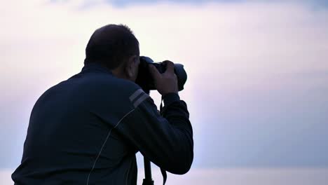 Blick-Auf-Einen-Männlichen-Fotografen,-Der-Während-Der-Blauen-Stunde-Mit-DSLR-Fotografiert