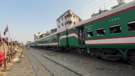 Blick-Auf-Die-Waggons-Eines-Zuges,-Der-Durch-Einen-Stadtmarkt-Mit-Gebäuden-Am-Gleisrand-In-Dhaka,-Bangladesch,-Fährt