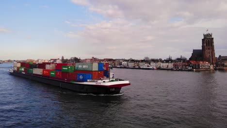 Vista-Aérea-De-Estribor-Del-Buque-De-Carga-Salute-Pasando-Por-Oude-Maas-Con-Nuestra-Señora-De-Dordrecht-En-Segundo-Plano