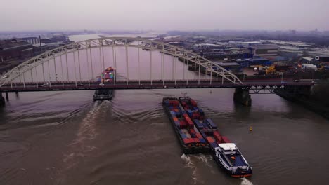 Aerial-View-Of-Maas-FPS-RIJN-Cargo-Ships-Passing-Underneath-Brug-Over-De-Noord