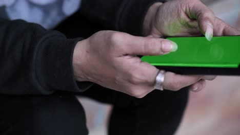 Manos-Asiáticas-Femeninas-Sosteniendo-Un-Teléfono-Inteligente-De-Pantalla-Verde-Escribiendo