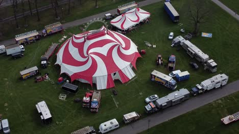 Planet-Zirkus-Draufgänger-Unterhaltung-Buntes-Wirbelzelt-Und-Wohnwagenanhängerring-Luftaufnahme-Hoch-Oben-Rechts-Kreisend