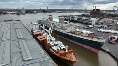 Altes-Stillgelegtes-Schiff-Neben-Neuem-Güterverkehr-Mit-Vielen-Booten