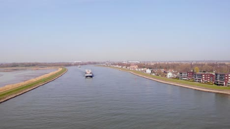 Antena-Sobre-El-Río-Noord-Con-Vistas-Al-Buque-Portacontenedores-De-Carga-De-Misuri-Que-Se-Aproxima-En-Un-Día-Soleado