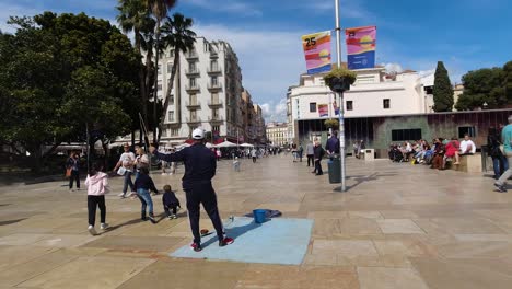 Male-street-busker-creating-soap-bubbles-to-play-with-kids-on-public-street