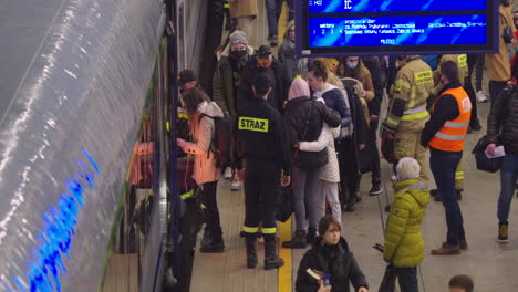 2022-Invasión-Rusa-De-Ucrania---Estación-Central-De-Trenes-En-Varsovia-Durante-La-Crisis-De-Refugiados---Bomberos-Ayudando-A-La-Gente-A-Entrar-Al-Tren