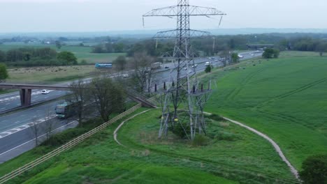 Aerial-view-above-traffic-vehicles-driving-on-busy-UK-M62-motorway-lanes-pan-right-tilt-up-shot