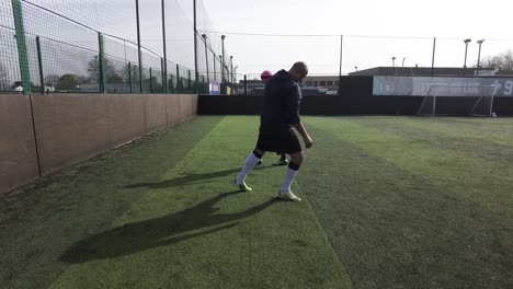 Two-Male-Friends-Doing-Warm-Up-Stretches-Before-Football-Game-At-Goals-On-17-April-2022