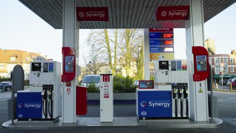 Time-lapse-of-people-and-car-passing-at-Esso-gas-station-in-Brussels,-Belgium