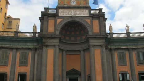 Low-angle-shot-of-Convitto-Nazionale-Vittorio-Emanuele-II,-Piazza-Dante,-Naples,-Italy,-full-of-tourists-on-a-cloudy-day