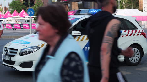 Close-up-of-police-car-with-flashing-lights-parked-at-outdoor-street-fair