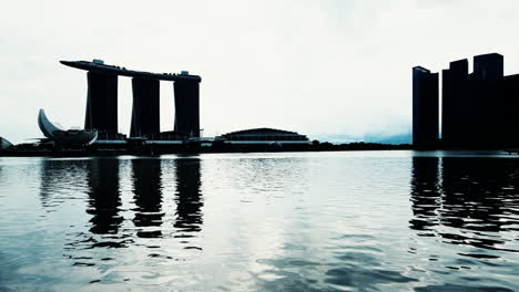 Silhouette-Des-MBS-Hotel-Und-Kunstwissenschaftsmuseums-An-Der-Marina-Bay-An-Einem-Ruhigen,-Bewölkten-Tag