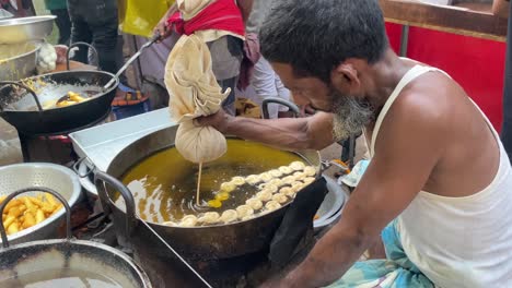 Un-Anciano-Haciendo-Jalebi-En-Espiral-Hecho-A-Mano-En-Un-Mercado-Al-Aire-Libre-En-Bangladesh