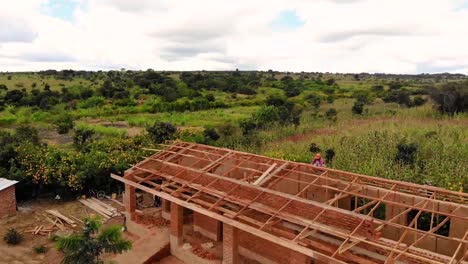 Construcción-Del-Techo-De-Una-Casa-De-Ladrillos-En-Un-Pueblo-Africano,-Vista-Aérea