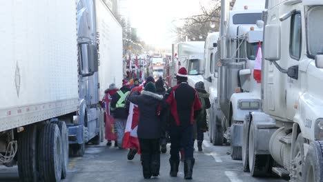 Canadienses-Con-Banderas-Caminan-Entre-Camiones-Durante-La-Protesta-Del-Convoy-De-La-Libertad