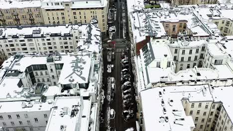 Vista-Aérea-De-Calles-Nevadas,-Revelando-El-Horizonte-De-Varsovia,-Invierno-En-Polonia---Ascendente,-Inclinación,-Disparo-De-Drones