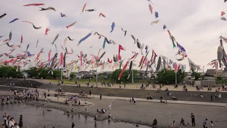 Los-Japoneses-Se-Reúnen-En-El-Parque-Para-La-Semana-Dorada,-Serpentinas-De-Carpa-Sobre-El-Río