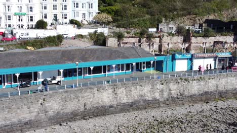 Colourful-Llandudno-seaside-amusement-arcade-holiday-souvenirs-stalls-aerial-view-North-Wales-right-dolly-zoom-in