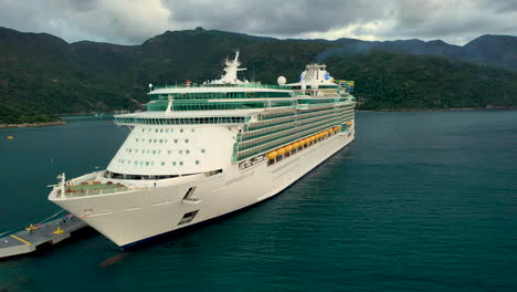 Cinematic-wide-rotating-drone-shot-of-a-docked-cruise-ship-in-the-Cayman-Islands