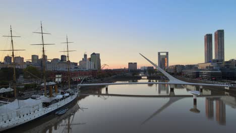 Dolly-Aéreo-A-La-Derecha-Del-Buque-Museo-Fragata-Sarmiento-Y-Puente-De-La-Mujer-En-Puerto-Madero,-Buenos-Aires