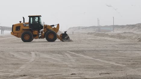 Cargadora-De-Ruedas-Caterpillar-Nivelando-Arena-Para-Reparar-Daños-En-La-Playa-Y-Las-Dunas