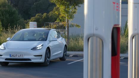 Weißer-Tesla-Wird-Von-Einer-Geschäftsfrau-In-Einer-Ladestation-Geparkt