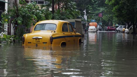 Vehículo-Taxi-Amarillo-Atascado-En-Una-Carretera-Inundada-En-Kolkata,-India