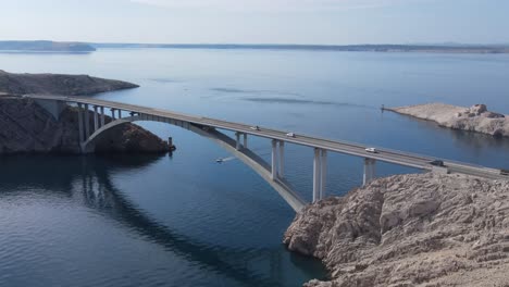 Una-Fila-De-Autos-Que-Pasan-Por-Un-Puente-De-Hormigón-En-Una-Isla-Pag,-Croacia,-Una-Vista-Aérea