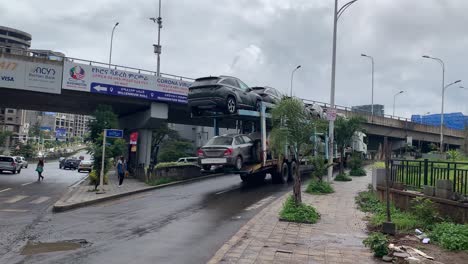 Car-carrier-trailer-is-moving-toward-the-car-shop-full-of-car-on-board