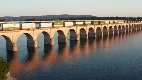 Cargo-train-crosses-bridge-at-golden-hour-sunset