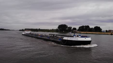 Aerial-Bow-View-Of-Montana-Tanker-Ship-Travelling-Along-River-Noord