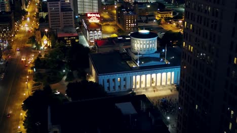 Luftaufnahme-Des-Ohio-Statehouse-Und-Des-Verkehrs-In-Der-Beleuchteten-Columbus-City-–-Rückwärtsgang,-Drohnenaufnahme