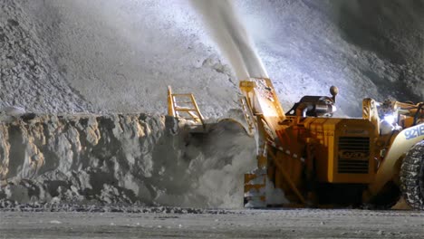 heavy-machine-clearing-a-pile-of-snow-and-spewing-it,-Canada-on-November-1,-2021