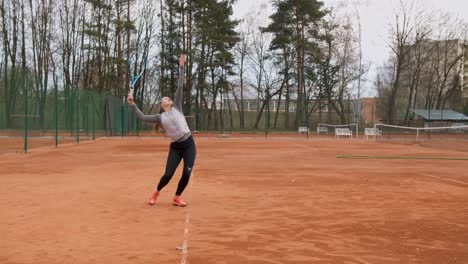 Los-Trenes-De-Las-Jóvenes-Tenistas-Profesionales-Sirven-En-El-Campo-De-Tenis-Al-Aire-Libre,-Tiro-Medio-Estático