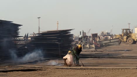 Schiffsbrecher-Mit-Lötlampe-Auf-Blechplatte-Auf-Dem-Boden-In-Gadani,-Pakistan