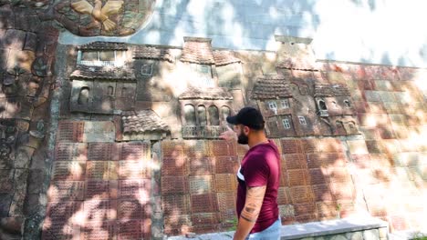 Tour-Guide-Showing-Off-Wall-Art-On-Side-Of-Building-In-Kakheti,-Georgia-On-Sunny-Day