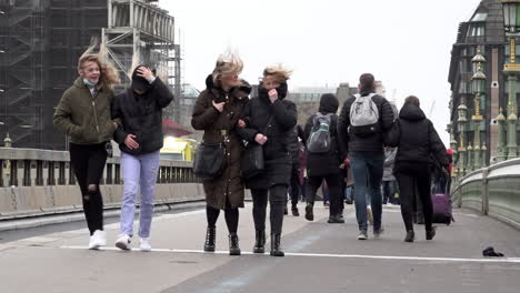 Frauenhaare-Werden-Herumgeweht,-Während-Menschen-Während-Des-Sturms-Eunice-In-Zeitlupe-Durch-Starken-Wind-über-Die-Westminster-Bridge-Laufen