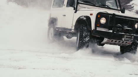 Toma-épica-Del-Land-Rover-Defender-D90-Giro-Brusco-A-La-Deriva-En-Un-Camino-Cubierto-De-Nieve