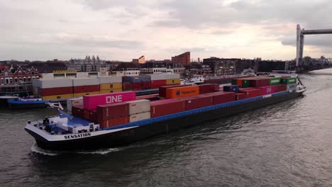 Vista-Lateral-Del-Puerto-Aéreo-Del-Buque-Portacontenedores-De-Carga-A-Lo-Largo-De-Oude-Maas-Dejando-El-Puente-Ferroviario-Spoorbrug-Elevado