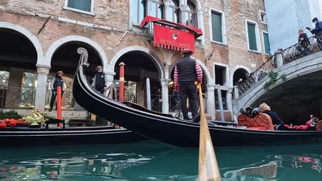 Venice-tour-with-gondola-and-gondolier-passing-under-Ponte-delle-Guglie-bridge-in-Italy